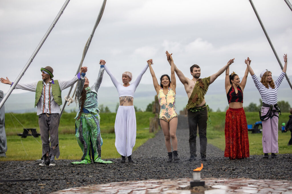 Performers standing outside in a row taking a bow.
